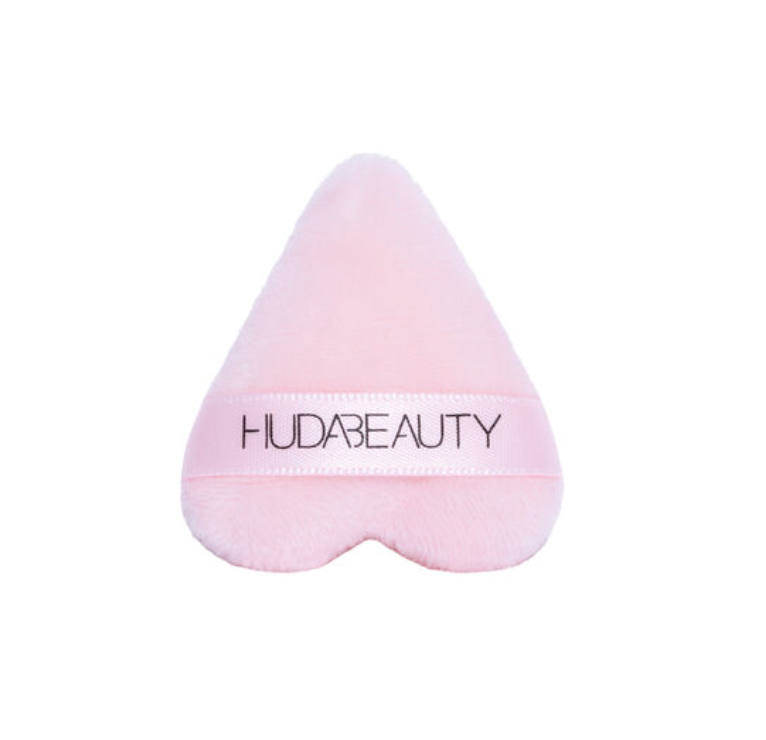 Light pink triangular makeup puffs by Huda Beauty,  designed for precise application.